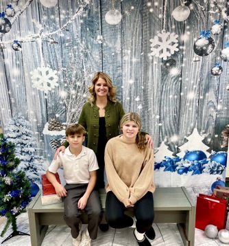 A family take a photo with a winter scene backdrop