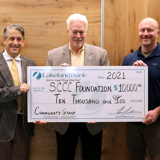 Three men holding a large check that reads SCCC Foundation Ten Thousand dollars from Lakeland Bank