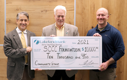 Three men holding a large check that reads Lakeland Bank, SCCC Foundation, ten thousand dollars.