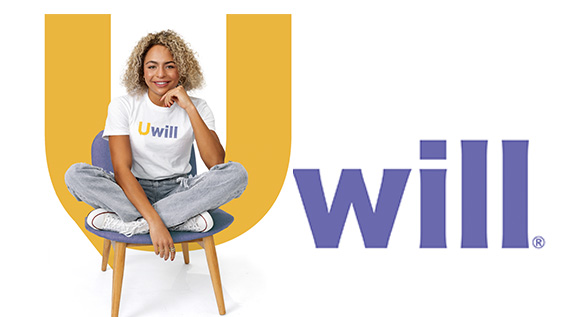 Woman sitting in a chair in front of the letter U.