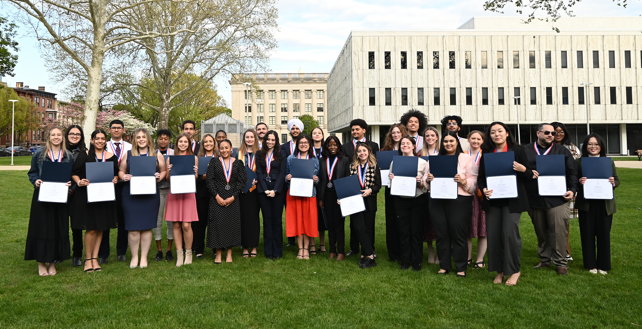 A group of 38 students gather for a picture holding awards.