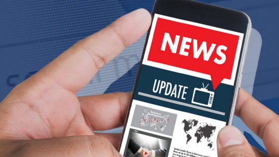 A person holding a phone with news on the screen