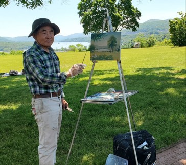 Man outside painting a landscape