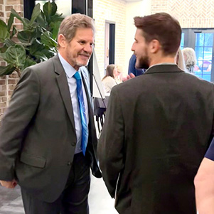 Two men standing chatting.