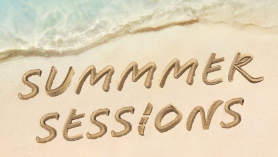 The words Summer Sessions written in the sand on the beach.