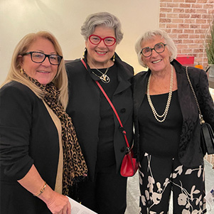 Three professional women standing at an event.